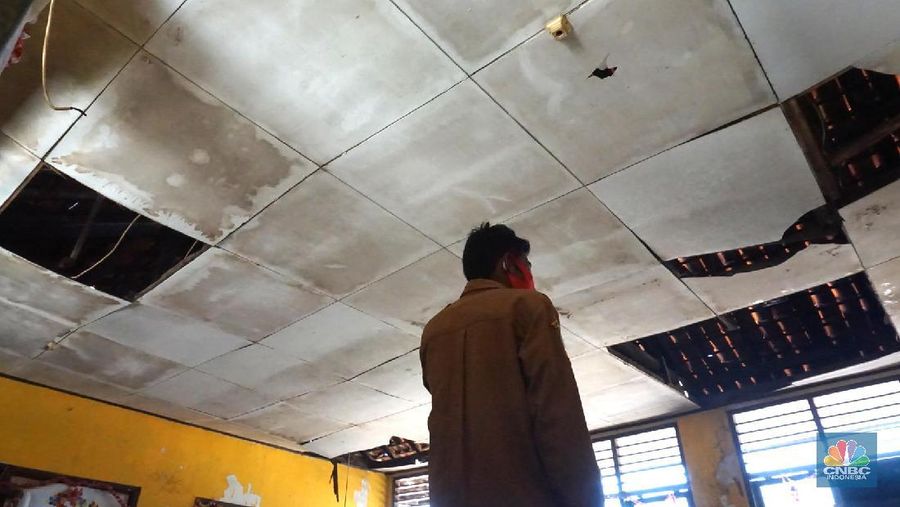 Pegawai mengamati bagian atap bangunan SDN Mekarsari 05 yang rusak di Tambun, Kabupaten Bekasi, Jawa Barat, Senin (27/7/2020). Menurut pihak sekolah, terdapat dua ruang kelas dan satu ruang guru yang kondisinya rusak dan tidak dapat digunakan lagi sejak tujuh bulan yang lalu. Bangunan ini rusak karena kondisi yang sudah tua. Menurut penjaga sekolah ini dibangun sejak 1984. Kondisi ruangan dalam kondisi rusak, rata-rata kerusakan pada bagian plafon yang sudah bolong-bolong.
(CNBC Indonesia/ Muhammad Sabki)