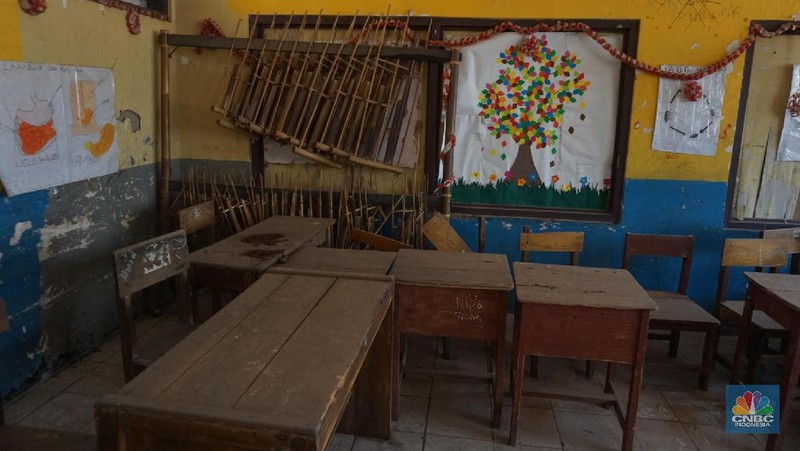 Pegawai mengamati bagian atap bangunan SDN Mekarsari 05 yang rusak di Tambun, Kabupaten Bekasi, Jawa Barat, Senin (27/7/2020). Menurut pihak sekolah, terdapat dua ruang kelas dan satu ruang guru yang kondisinya rusak dan tidak dapat digunakan lagi sejak tujuh bulan yang lalu. Bangunan ini rusak karena kondisi yang sudah tua. Menurut penjaga sekolah ini dibangun sejak 1984.  Kondisi ruangan dalam kondisi rusak, rata-rata kerusakan pada bagian plafon yang sudah bolong-bolong. 
 (CNBC Indonesia/ Muhammad Sabki)
