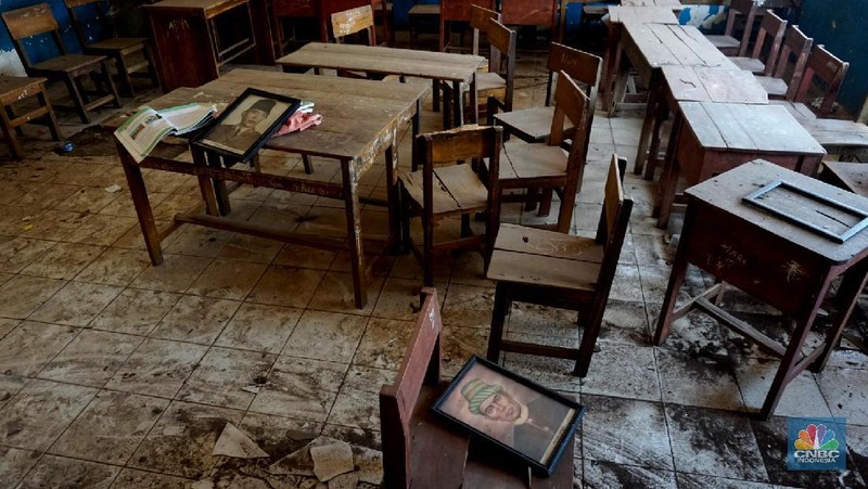 Pegawai mengamati bagian atap bangunan SDN Mekarsari 05 yang rusak di Tambun, Kabupaten Bekasi, Jawa Barat, Senin (27/7/2020). Menurut pihak sekolah, terdapat dua ruang kelas dan satu ruang guru yang kondisinya rusak dan tidak dapat digunakan lagi sejak tujuh bulan yang lalu. Bangunan ini rusak karena kondisi yang sudah tua. Menurut penjaga sekolah ini dibangun sejak 1984.  Kondisi ruangan dalam kondisi rusak, rata-rata kerusakan pada bagian plafon yang sudah bolong-bolong. 
 (CNBC Indonesia/ Muhammad Sabki)
