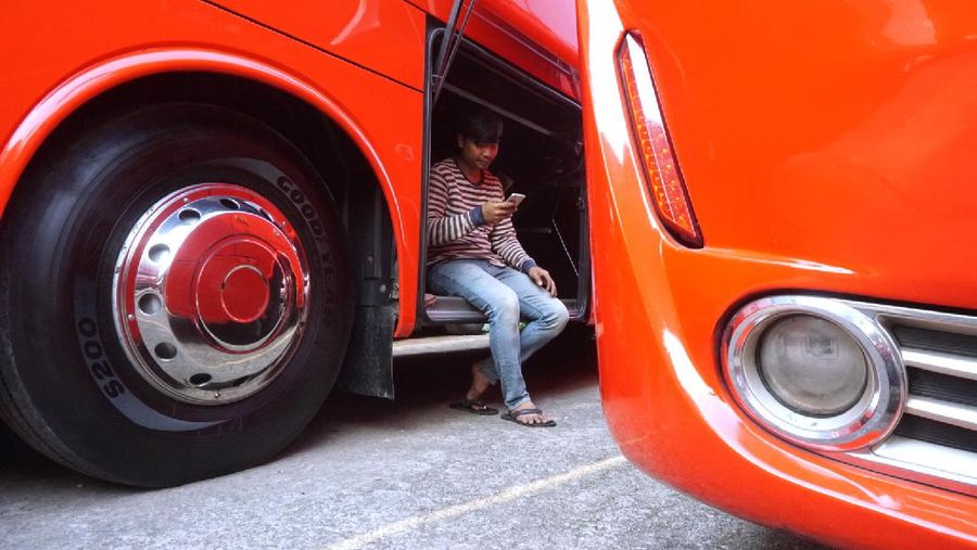 Petugas merapihkan deretan bus di Pool Bus Pariwisata Kawasan Tanjung Barat, Jakarta Selatan, Selasa (28/7/2020). Masih diberlakukannya Pembatasan Sosial Bersekala Besar (PSBB) dan penutupan tempat rekreasi akibat Covid-19, berimbas pada jasa transportasi pariwisata. 

Penutupan obyek wisata dan imbauan untuk tidak ke tempat keramaian demi mencegah penyebaran corona (covid-19) membuat Perusahaan Otobus (PO) pariwisata mengandangkan armadanya. Padahal, momen sebelum datangnya Ramadhan merupakan waktunya para pemilik perusahaan otobus panen rezeki.
PO terpaksa mengandangkan armadanya karena berbagai acara keluar kota dibatalkan. Permasalahan tak berhenti di situ saja, bayang-bayang setoran cicilan ke perusahaan leasing juga menghantui para pemilik PO ini. 

Fajar, Head Marketing bus Manhattan, pada CNBC Indonesia, menjelaskan para usaha bus sejak pandemi ini terpuruk. Apalagi, menurut Fajar, pesanan bus biasanya sudah ramai lagi pada H-7 Lebaran kemarin.

Dengan kondisi seperti ini, banyak bus yang dikandangkan, akibatnya membuat pemasukan tidak ada.

