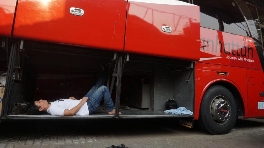 Petugas merapihkan deretan bus di Pool Bus Pariwisata Kawasan Tanjung Barat, Jakarta Selatan, Selasa (28/7/2020). Masih diberlakukannya Pembatasan Sosial Bersekala Besar (PSBB) dan penutupan tempat rekreasi akibat Covid-19, berimbas pada jasa transportasi pariwisata. 

Penutupan obyek wisata dan imbauan untuk tidak ke tempat keramaian demi mencegah penyebaran corona (covid-19) membuat Perusahaan Otobus (PO) pariwisata mengandangkan armadanya. Padahal, momen sebelum datangnya Ramadhan merupakan waktunya para pemilik perusahaan otobus panen rezeki.
PO terpaksa mengandangkan armadanya karena berbagai acara keluar kota dibatalkan. Permasalahan tak berhenti di situ saja, bayang-bayang setoran cicilan ke perusahaan leasing juga menghantui para pemilik PO ini. 

Fajar, Head Marketing bus Manhattan, pada CNBC Indonesia, menjelaskan para usaha bus sejak pandemi ini terpuruk. Apalagi, menurut Fajar, pesanan bus biasanya sudah ramai lagi pada H-7 Lebaran kemarin.

Dengan kondisi seperti ini, banyak bus yang dikandangkan, akibatnya membuat pemasukan tidak ada.

