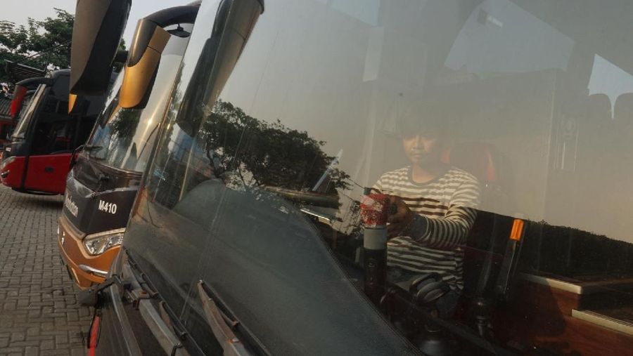 Petugas merapihkan deretan bus di Pool Bus Pariwisata Kawasan Tanjung Barat, Jakarta Selatan, Selasa (28/7/2020). Masih diberlakukannya Pembatasan Sosial Bersekala Besar (PSBB) dan penutupan tempat rekreasi akibat Covid-19, berimbas pada jasa transportasi pariwisata. 

Penutupan obyek wisata dan imbauan untuk tidak ke tempat keramaian demi mencegah penyebaran corona (covid-19) membuat Perusahaan Otobus (PO) pariwisata mengandangkan armadanya. Padahal, momen sebelum datangnya Ramadhan merupakan waktunya para pemilik perusahaan otobus panen rezeki.
PO terpaksa mengandangkan armadanya karena berbagai acara keluar kota dibatalkan. Permasalahan tak berhenti di situ saja, bayang-bayang setoran cicilan ke perusahaan leasing juga menghantui para pemilik PO ini. 

Fajar, Head Marketing bus Manhattan, pada CNBC Indonesia, menjelaskan para usaha bus sejak pandemi ini terpuruk. Apalagi, menurut Fajar, pesanan bus biasanya sudah ramai lagi pada H-7 Lebaran kemarin.

Dengan kondisi seperti ini, banyak bus yang dikandangkan, akibatnya membuat pemasukan tidak ada.

