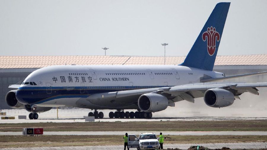 Airport crew watch from their car as a China Southern Airlines passenger jet lands during the first test flight of the new Beijing Daxing International Airport on Monday, May 13, 2019. According to China state media Xinhua, the airport completed its first test flight of passenger planes as four aircraft landed safely on the runway Monday morning. Located 46 kilometers (28 miles) from downtown Beijing, the airport will go into operations before Sept. 30 to relieve pressure from the current overcrowded airports with added capacity for 45 million passengers annually by 2021. (AP Photo/Ng Han Guan)