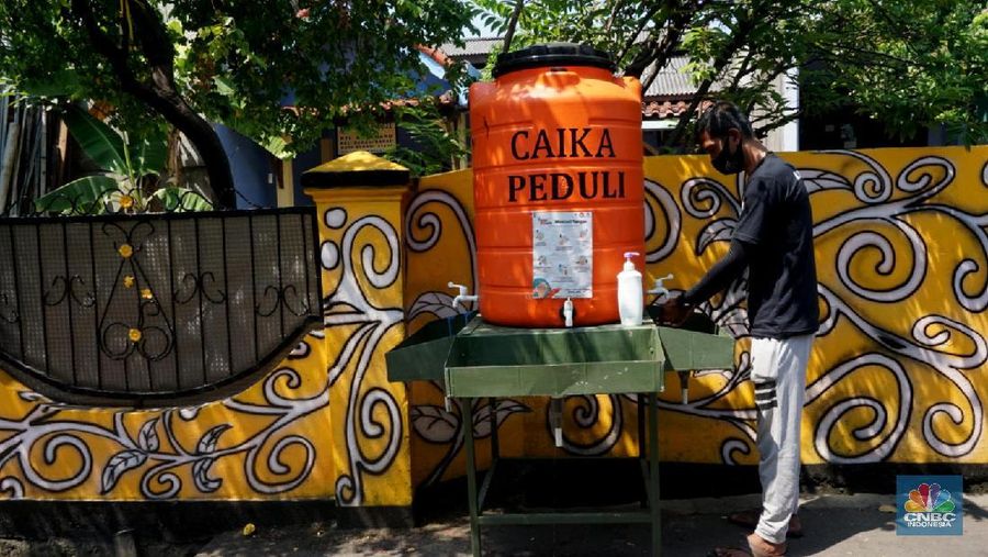 Warga mengenakan masker di Kawasan Kampung Rawa Pasung RW 022, Kelurahan Kota Baru, Kecamatan Bekasi Barat, Kota Bekasi, Jawa Barat, Selasa (28/7/2020).

Lokasi yang berbatasan dengan Jakarta Timur ini , kampung rawa pasung bekasi ini dikenal sebagai wilayah zona hijau sejak awal pandemi Maret lalu.

Beragam mural berisi pesan kepatuhan terhadap protokol kesehatan menghiasi gang sempit di kawasan hunian padat tersebut.

Warga sukarela memberikan paket sembako gratis bagi warga lain yang membutuhkan dan menyediakan ruang isolasi mandiri untuk yang terkena Covid-19.

Pak Soleh selaku ketua RW mengklaim bahwa kampung tersebut 0 positif Corona dan masuk zona hijau. 