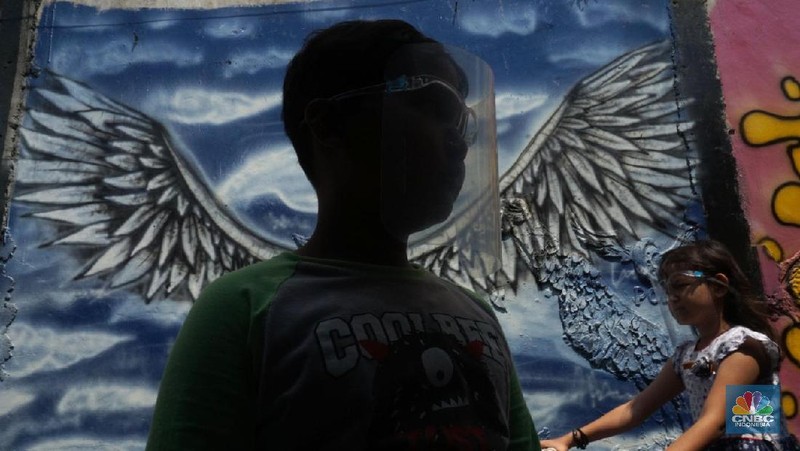 Warga mengenakan masker di Kawasan Kampung Rawa Pasung RW 022, Kelurahan Kota Baru, Kecamatan Bekasi Barat, Kota Bekasi, Jawa Barat, Selasa (28/7/2020).

Lokasi yang berbatasan dengan Jakarta Timur ini , kampung rawa pasung bekasi ini dikenal sebagai wilayah zona hijau sejak awal pandemi Maret lalu.

Beragam mural berisi pesan kepatuhan terhadap protokol kesehatan menghiasi gang sempit di kawasan hunian padat tersebut.

Warga sukarela memberikan paket sembako gratis bagi warga lain yang membutuhkan dan menyediakan ruang isolasi mandiri untuk yang terkena Covid-19.

Pak Soleh selaku ketua RW mengklaim bahwa kampung tersebut 0 positif Corona dan masuk zona hijau. 