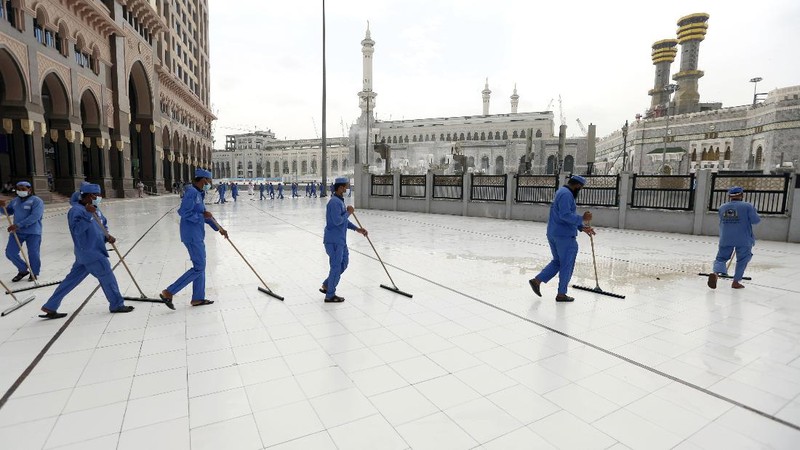 Workers disinfect the ground outside the Grand Mosque, over fears of the new coronavirus, at the Muslim holy city of Mecca, Saudi Arabia, Monday, July 27, 2020. Anywhere from 1,000 to 10,000 pilgrims will be allowed to perform the annual hajj pilgrimage this year due to the coronavirus pandemic. (AP Photo)