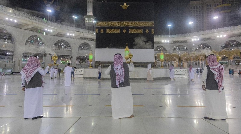 Workers disinfect the ground outside the Grand Mosque, over fears of the new coronavirus, at the Muslim holy city of Mecca, Saudi Arabia, Monday, July 27, 2020. Anywhere from 1,000 to 10,000 pilgrims will be allowed to perform the annual hajj pilgrimage this year due to the coronavirus pandemic. (AP Photo)