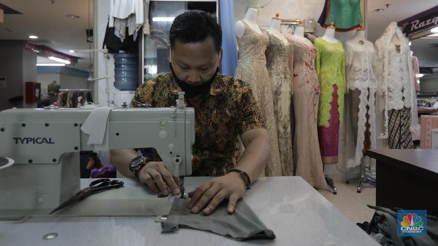 Luasnya Penyebaran Virus corona di Indonesia Termasuk Kota Jakarta sangat berpengaruh terhadap omzet pendapatan para tukang jahit gaun pengantin di Mayestik, Kebayoran Baru, Jakarta Selatan, Selasa (28/7/20). (վ/Tri Susilo)

Bukan tanpa alasan, sepinya pelanggan akibat aturan Pemerintah dengan merumahkan hampir seluruh ASN, kebijakan yang wewajibkan setiap warga harus tetap berdiam diri dirumah jika tidak ada keperluan penting di luar rumah.    

Serta rasa takut warga beraktivitas di luar rumah menjadi faktor omzet penjahit di Mayestik terus menurun.

Aris salah satu penjahit di Mayestik mengatakan, hampir 4 bulan terakhir ini omzet pendapatannya menurun drastis akibat adanya pandemi COVID-19 yang melanda seluruh dunia bahkan di Kota Jakarta sendiri.

Menurutnya, turunnya pendapatan para tukang jahit lantaran sepinya pelanggan yang datang akibat adanya pandemi ini.    

Aris mengatakan kebanyakan pelanggan yang dimiliki biasanya datang kalangan anak muda atau yang ungin menikah dengan mendesain baju pengantin yang di minginkan konsumen.

Namun dengan adanya peraturan pemerintah yang merumahkan hampir seluruh ASN dan kebijakan bagi warga untuk berdiam di rumah masing-masing secara langsung berdampak pada omzet penjualnnya.  

Aris mengaku, jika hari biasanya sebelum masuknya COVID-19 di Indonesia pendapatanya bisa mencapai Rp 30 juta hingga Rp 45 juta perbulan. Setelah masuknya COVID-19 pemasukan hanya 1,5 juta perbulan.

Pihak pengelola gedung berinisiatif memberikan keringanan berupa pembayaran ruko sewa sebedar 50% hingga waktu yang belum ditentukan. (վ/ Tri Susilo)