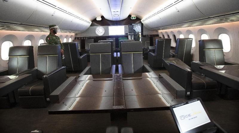A soldier stands guard inside the former Mexican presidential plane during a media tour following the daily, morning press conference of Mexican President Andres Manuel Lopez Obrador at Benito Juarez International Airport in Mexico City, Monday, July 27, 2020. The president, who only flies commercial as one measure in his austerity government, has been trying to sell the plane since he took office. (AP Photo/Marco Ugarte)