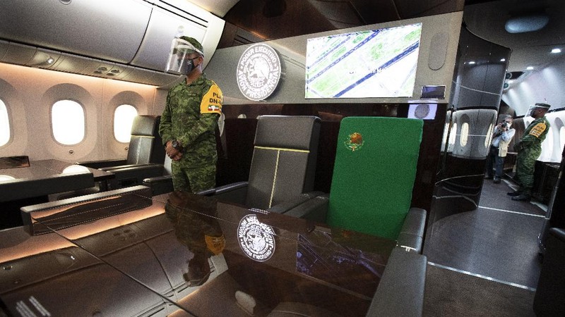 A soldier stands guard inside the former Mexican presidential plane during a media tour following the daily, morning press conference of Mexican President Andres Manuel Lopez Obrador at Benito Juarez International Airport in Mexico City, Monday, July 27, 2020. The president, who only flies commercial as one measure in his austerity government, has been trying to sell the plane since he took office. (AP Photo/Marco Ugarte)