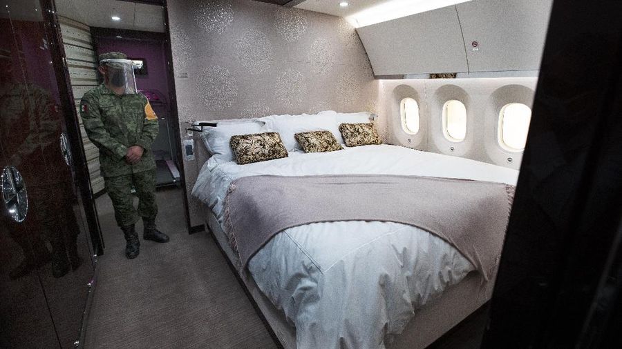 A soldier stands guard inside the former Mexican presidential plane during a media tour following the daily, morning press conference of Mexican President Andres Manuel Lopez Obrador at Benito Juarez International Airport in Mexico City, Monday, July 27, 2020. The president, who only flies commercial as one measure in his austerity government, has been trying to sell the plane since he took office. (AP Photo/Marco Ugarte)