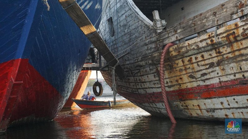 Sayup suara ombak menyusup hingga ke ruang-ruang sempit Kapal yang tengah bersandar di Pelabuhan Sunda Kelapa, Jakarta Utara, Rabu (29/7/2020) petang itu. Sejumlah anak dengan berani tengah asik melompat bergantian dari atas kapal, sambil berteriak.
Sunda Kelapa adalah nama pelabuhan yang berada di ujung utara Jakarta. Pelabuhan ini sudah ada sejak ratusan tahun lalu. Pada zaman kerajaan, Sunda Kelapa adalah pusat perdagangan. Kini, meski telah dimakan usia, pelabuhan ini masih tetap ramai.
Banyak orang mengais rezeki di Pelabuhan Sunda Kelapa. Ada pedagang, nelayan, Anak Buah Kapal (ABK), pemberi jasa sampan, hingga buruh angkut. Semua tumpah ruah menjadi satu. Namun bagi anak-anak sunda kelapa adalah tempat paling asik untuk bermain.

Pelabuhan Sunda Kelapa lambat laun tidak terlihat sesibuk saat masa jayanya. Kini, pelabuhan tersebut dikelola oleh PT Pelindo II dan tidak mengantongi sertifikasi International Ship and Port Security karena sifat pelayanan jasanya hanya untuk melayani kapal antar pulau di dalam negeri.

Dari sisi ekonomi pelabuhan ini masih cukup strategis, mengingat berdekatan dengan pusat-pusat perdagangan di Jakarta seperti Glodok, Pasar Pagi, Mangga Dua, dan lain-lainnya. Menjadi buruh kuli angkut mungkin bukan hal yang dicita-citakn oleh banyak orang. Namun ketika tidak ada lagi keahlian yang bisa ditawarkan selain tenaga kasar maka menjadi buruh kasar sebagai kuli angkut pun harus dijalani.

Setidaknya ini yang tertangkap saat melihat potret para kuli angkut di Pelabuhan Sunda Kelapa Jakarta Utara. Dalam sehari para pekerja kuli angkut ini mampu membongkar muatan dengan berat total 300ton. Beban sebesar ini dikerjakan oleh 20an orang pekerja.  (CNBC Indonesia/ Muhammad Sabki)