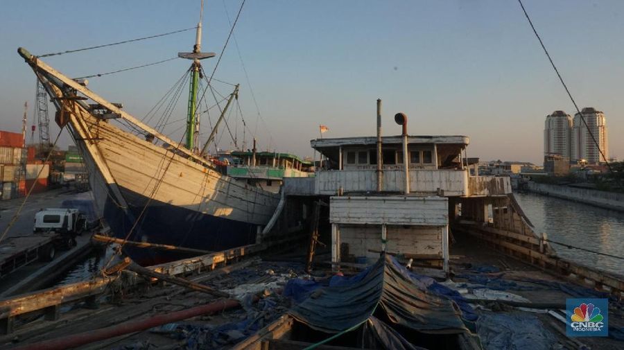 Sayup suara ombak menyusup hingga ke ruang-ruang sempit Kapal yang tengah bersandar di Pelabuhan Sunda Kelapa, Jakarta Utara, Rabu (29/7/2020) petang itu. Sejumlah anak dengan berani tengah asik melompat bergantian dari atas kapal, sambil berteriak.
Sunda Kelapa adalah nama pelabuhan yang berada di ujung utara Jakarta. Pelabuhan ini sudah ada sejak ratusan tahun lalu. Pada zaman kerajaan, Sunda Kelapa adalah pusat perdagangan. Kini, meski telah dimakan usia, pelabuhan ini masih tetap ramai.
Banyak orang mengais rezeki di Pelabuhan Sunda Kelapa. Ada pedagang, nelayan, Anak Buah Kapal (ABK), pemberi jasa sampan, hingga buruh angkut. Semua tumpah ruah menjadi satu. Namun bagi anak-anak sunda kelapa adalah tempat paling asik untuk bermain.

Pelabuhan Sunda Kelapa lambat laun tidak terlihat sesibuk saat masa jayanya. Kini, pelabuhan tersebut dikelola oleh PT Pelindo II dan tidak mengantongi sertifikasi International Ship and Port Security karena sifat pelayanan jasanya hanya untuk melayani kapal antar pulau di dalam negeri.

Dari sisi ekonomi pelabuhan ini masih cukup strategis, mengingat berdekatan dengan pusat-pusat perdagangan di Jakarta seperti Glodok, Pasar Pagi, Mangga Dua, dan lain-lainnya. Menjadi buruh kuli angkut mungkin bukan hal yang dicita-citakn oleh banyak orang. Namun ketika tidak ada lagi keahlian yang bisa ditawarkan selain tenaga kasar maka menjadi buruh kasar sebagai kuli angkut pun harus dijalani.

Setidaknya ini yang tertangkap saat melihat potret para kuli angkut di Pelabuhan Sunda Kelapa Jakarta Utara. Dalam sehari para pekerja kuli angkut ini mampu membongkar muatan dengan berat total 300ton. Beban sebesar ini dikerjakan oleh 20an orang pekerja.  (CNBC Indonesia/ Muhammad Sabki)