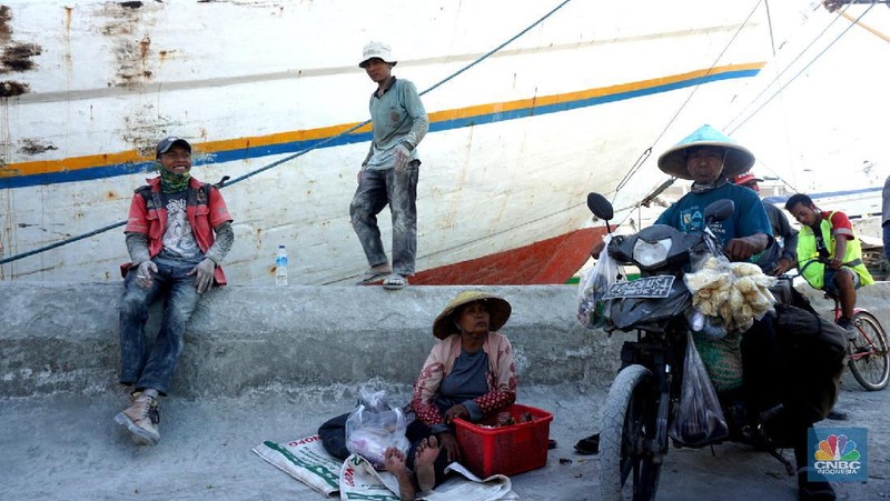 Sayup suara ombak menyusup hingga ke ruang-ruang sempit Kapal yang tengah bersandar di Pelabuhan Sunda Kelapa, Jakarta Utara, Rabu (29/7/2020) petang itu. Sejumlah anak dengan berani tengah asik melompat bergantian dari atas kapal, sambil berteriak.
Sunda Kelapa adalah nama pelabuhan yang berada di ujung utara Jakarta. Pelabuhan ini sudah ada sejak ratusan tahun lalu. Pada zaman kerajaan, Sunda Kelapa adalah pusat perdagangan. Kini, meski telah dimakan usia, pelabuhan ini masih tetap ramai.
Banyak orang mengais rezeki di Pelabuhan Sunda Kelapa. Ada pedagang, nelayan, Anak Buah Kapal (ABK), pemberi jasa sampan, hingga buruh angkut. Semua tumpah ruah menjadi satu. Namun bagi anak-anak sunda kelapa adalah tempat paling asik untuk bermain.

Pelabuhan Sunda Kelapa lambat laun tidak terlihat sesibuk saat masa jayanya. Kini, pelabuhan tersebut dikelola oleh PT Pelindo II dan tidak mengantongi sertifikasi International Ship and Port Security karena sifat pelayanan jasanya hanya untuk melayani kapal antar pulau di dalam negeri.

Dari sisi ekonomi pelabuhan ini masih cukup strategis, mengingat berdekatan dengan pusat-pusat perdagangan di Jakarta seperti Glodok, Pasar Pagi, Mangga Dua, dan lain-lainnya. Menjadi buruh kuli angkut mungkin bukan hal yang dicita-citakn oleh banyak orang. Namun ketika tidak ada lagi keahlian yang bisa ditawarkan selain tenaga kasar maka menjadi buruh kasar sebagai kuli angkut pun harus dijalani.

Setidaknya ini yang tertangkap saat melihat potret para kuli angkut di Pelabuhan Sunda Kelapa Jakarta Utara. Dalam sehari para pekerja kuli angkut ini mampu membongkar muatan dengan berat total 300ton. Beban sebesar ini dikerjakan oleh 20an orang pekerja.  (CNBC Indonesia/ Muhammad Sabki)