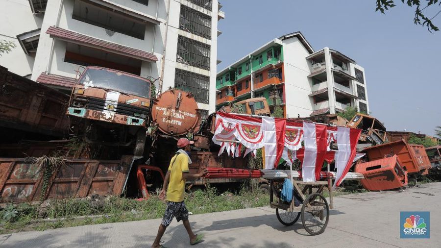 Kendaraan armada tua menumpuk dibelakang rusun Cengkareng, Jakarta Barat, Rabu (29/7/20). (CNBC Indonesia/Tri Susilo) 

Lahan rusun belakang Cengkareng, Jakarta Barat menjadi tempat penampungan kendaraan pengangkut sampah tua yang tak lagi dipakai.

Berdasarkan pantauan CNBC Indonesia pada Rabu (29/7/20), belakang halaman rusun tersebut dipenuhi truk sampah yang terlihat tua. Beberapa bagiannya berkarat dan keropos. Truk sampah itu ditumpuk begitu saja.

Dulunya mobil-mobil tak terpakai tersebut diletakkan berbaris di halaman belakang rusun Cengkareng Hingga akhirnya, pihak Sudin Lingkungan Hidup Jakarta Barat bersiasat untuk meletakkannya secara bertumpuk.   

Ada kurang lebih 30 kendaraan kendaraan yang terparkir di halaman rusun tersebut . Ada pula mobil tangki air yang diparkir di atas tumpukan.   

Kondisi kendaraan-kendaraan tersebut berbeda-beda. Ada yang sudah tak memiliki ban, kaca pecah, bodi penyok, jok mobil reyot dan lainnya.  

Dilokasi pemumpukan kendaraan dimanfaatkan sebagian warga mencari rumput untuk pakan hewan mereka.

Kondisi ini dimanfaatkan anak anak yang tidur didalam tumpukan kendaraan.

 kendaraan tersebut sudah tidak layak pakai. Kendaraan itu ada sejak 1997 dan kini rusak. (CNBC Indonesia/ Tri Susilo)