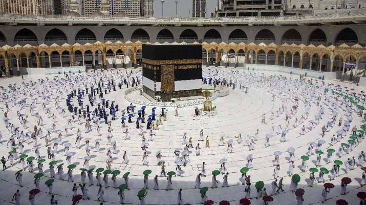 Ibadah Haji di Masa Pandemi In this photo released by the Saudi Media Ministry, limited numbers of pilgrims, move several feet apart, circling the cube-shaped Kaaba in the first rituals of the hajj, as they keep social distancing to help prevent the spread of the coronavirus, in the Muslim holy city of Mecca, Saudi Arabia, Wednesday, July 29, 2020. The hajj, which started on Wednesday, is intended to bring about greater humility and unity among Muslims. (Saudi Media Ministry via AP)
