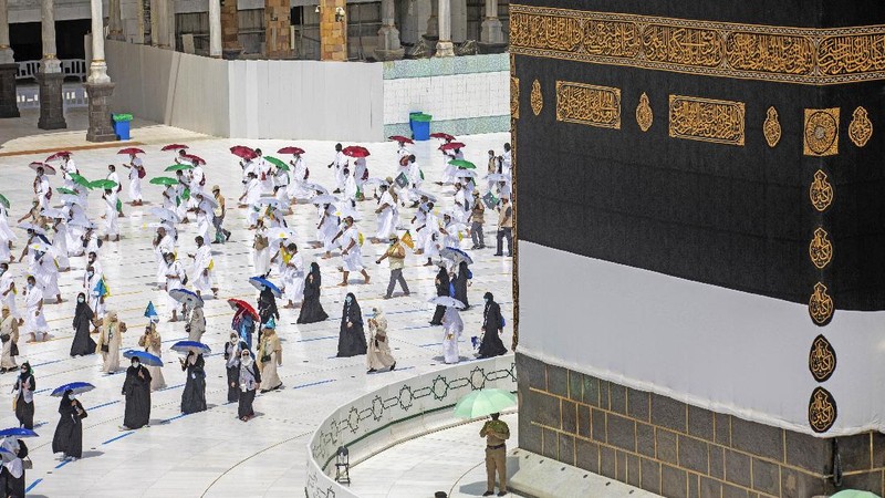 In this photo released by the Saudi Media Ministry, a limited numbers of pilgrims move several feet apart, circling the cube-shaped Kaaba in the first rituals of the hajj, as they keep social distancing to limit exposure and the potential transmission of the coronavirus, at the Grand Mosque in the Muslim holy city of Mecca, Saudi Arabia, Wednesday, July 29, 2020. The hajj, which started on Wednesday, is intended to bring about greater humility and unity among Muslims. (Saudi Media Ministry via AP)
