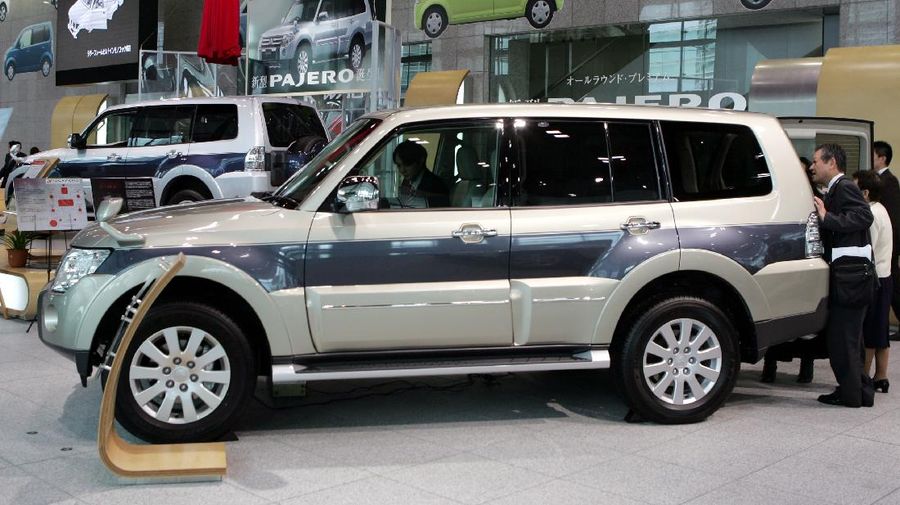 Visitors look at Mitsubishi Motors Corp.'s fully redesigned Pajero, the Japanese automaker's flagship SUV, at its headquarters in Tokyo Wednesday, Oct. 4, 2006. Mitsubishi Motors launched two types of new Pajeros, seven-seater long-body and five-seater short-body models, for the Japanese markets for the first time in seven years. (AP Photo/Katsumi Kasahara)