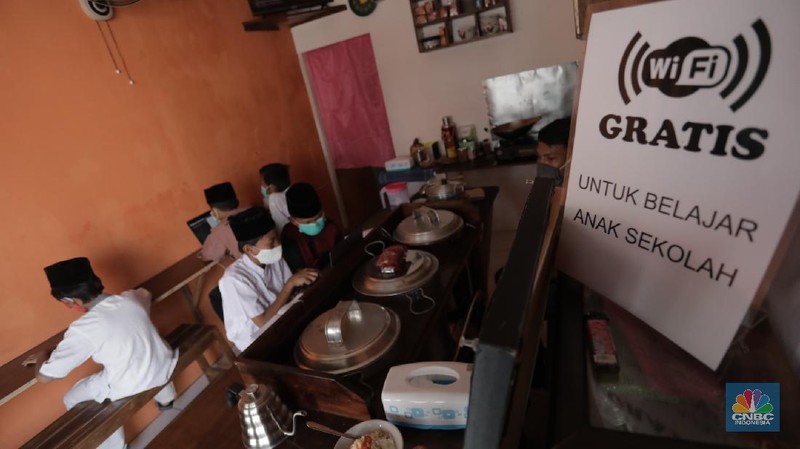 Gerai warung kopi di Tangerang Selatan menyediakan fasilitas internet gratis untuk membantu para pelajar mengikuti belajar daring. Kamis, (30/7/20). (CNBC Indonesia/Tri Susilo)

Warung kopi (warkop) di kawasan Pondok Aren, Tangerang Selatan, sediakan internet gratis untuk siswa yang kesulitan mengikuti proses belajar daring.

Rizki, selaku pemilik warung kopi mengaku tergerak untuk membantu para siswa di sekitar tempat usahanya lantaran banyak yang kesulitan mengikuti kegiatan belajar jarak jauh karena kesulitan membeli kuota internet, atau bahkan hanya memiliki satu ponsel yang digunakan orangtua mereka untuk bekerja.   

Kita kan baru mulai hari ini, alhamdulillah cukup tinggi antusiasnya. Karena kebanyakan orangtuanya cuma punya satu ponsel. Kayak yang kerjanya ojol, jadi dibawa buat tarik penumpang,