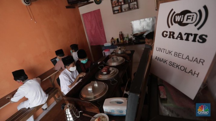 Gerai warung kopi di Tangerang Selatan menyediakan fasilitas internet gratis untuk membantu para pelajar mengikuti belajar daring. Kamis, (30/7/20). (CNBC Indonesia/Tri Susilo) Gerai warung kopi di Tangerang Selatan menyediakan fasilitas internet gratis untuk membantu para pelajar mengikuti belajar daring. Kamis, (30/7/20). (CNBC Indonesia/Tri Susilo)
Warung kopi (warkop) di kawasan Pondok Aren, Tangerang Selatan, sediakan internet gratis untuk siswa yang kesulitan mengikuti proses belajar daring.
Rizki, selaku pemilik warung kopi mengaku tergerak untuk membantu para siswa di sekitar tempat usahanya lantaran banyak yang kesulitan mengikuti kegiatan belajar jarak jauh karena kesulitan membeli kuota internet, atau bahkan hanya memiliki satu ponsel yang digunakan orangtua mereka untuk bekerja.
Kita kan baru mulai hari ini, alhamdulillah cukup tinggi antusiasnya. Karena kebanyakan orangtuanya cuma punya satu ponsel. Kayak yang kerjanya ojol, jadi dibawa buat tarik penumpang,