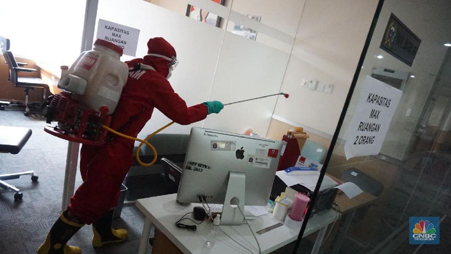 Petugas damkar menyemprot disinfektan di Gedung DPRD DKI, Jakarta, Kamis (30/7). (CNBC Indonesia/ Muhammad Sabki)