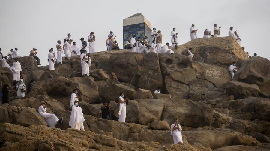 Muslim pilgrims pray on top of the rocky hill known as Mountain of Mercy on the Plain of Arafat during the annual hajj pilgrimage near the holy city of Mecca, Saudi Arabia, Thursday, July 30, 2020. Only about 1,000 pilgrims will be allowed to perform the annual hajj pilgrimage this year due to the virus pandemic. (Saudi Ministry of Media via AP)
