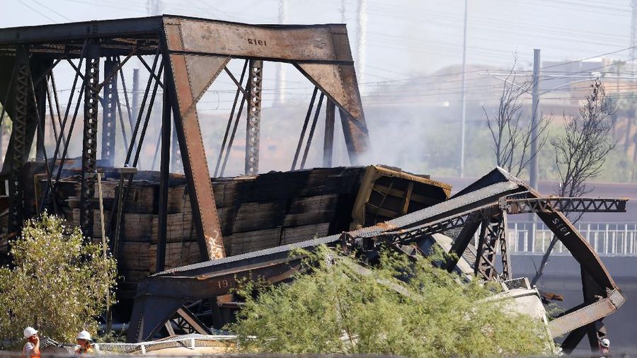 Smoke fills the sky at the scene of a train derailment in Tempe, Ariz., on Wednesday, July 29, 2020. Officials say a freight train traveling on a bridge that spans a lake in the Phoenix suburb derailed and set the bridge ablaze and partially collapsing the structure.  There were no immediate reports of any leaks. (Daniel Coronado via AP)