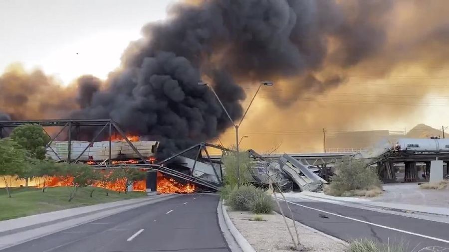 Smoke fills the sky at the scene of a train derailment in Tempe, Ariz., on Wednesday, July 29, 2020. Officials say a freight train traveling on a bridge that spans a lake in the Phoenix suburb derailed and set the bridge ablaze and partially collapsing the structure.  There were no immediate reports of any leaks. (Daniel Coronado via AP)