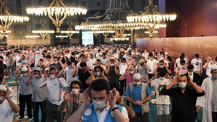 Muslims, wearing protective masks as a precaution against infection from coronavirus, gather for the Eid al-Adha prayer inside the Byzantine-era Hagia Sophia, recently converted back to a mosque, in the historic Sultanahmet district of Istanbul, Friday, July 31, 2020. Small groups of pilgrims performed one of the final rites of the Islamic hajj on Friday as Muslims worldwide marked the start of the Eid al-Adha holiday amid a global pandemic that has impacted nearly every aspect of this year’s pilgrimage and celebrations. The last days of hajj coincide with the four-day Eid al-Adha, or “Feast of Sacrifice,” in which Muslims slaughter livestock and distribute the meat to the poor.  (Pool via AP)