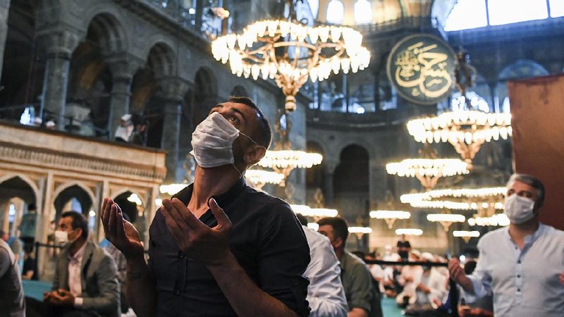 Muslims, wearing protective masks as a precaution against infection from coronavirus, gather for the Eid al-Adha prayer inside the Byzantine-era Hagia Sophia, recently converted back to a mosque, in the historic Sultanahmet district of Istanbul, Friday, July 31, 2020. Small groups of pilgrims performed one of the final rites of the Islamic hajj on Friday as Muslims worldwide marked the start of the Eid al-Adha holiday amid a global pandemic that has impacted nearly every aspect of this year’s pilgrimage and celebrations. The last days of hajj coincide with the four-day Eid al-Adha, or “Feast of Sacrifice,” in which Muslims slaughter livestock and distribute the meat to the poor.  (Pool via AP)