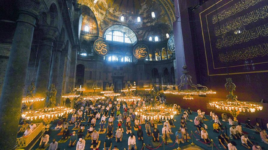 Muslims, wearing protective masks as a precaution against infection from coronavirus, gather for the Eid al-Adha prayer inside the Byzantine-era Hagia Sophia, recently converted back to a mosque, in the historic Sultanahmet district of Istanbul, Friday, July 31, 2020. Small groups of pilgrims performed one of the final rites of the Islamic hajj on Friday as Muslims worldwide marked the start of the Eid al-Adha holiday amid a global pandemic that has impacted nearly every aspect of this year’s pilgrimage and celebrations. The last days of hajj coincide with the four-day Eid al-Adha, or “Feast of Sacrifice,” in which Muslims slaughter livestock and distribute the meat to the poor.  (Pool via AP)