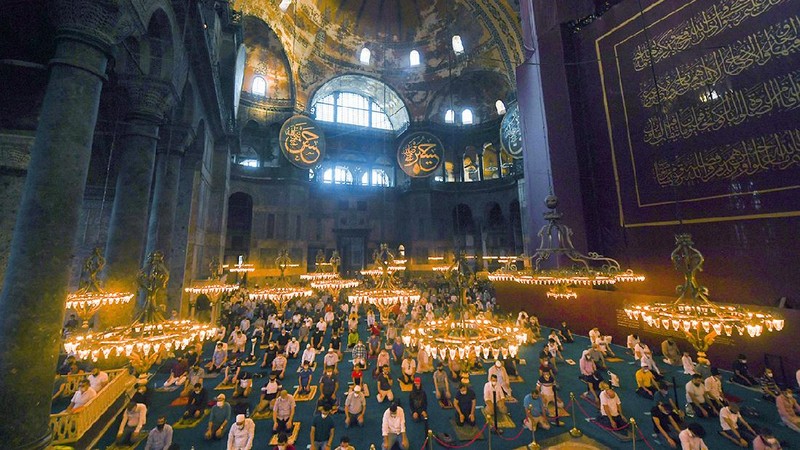 Muslims, wearing protective masks as a precaution against infection from coronavirus, gather for the Eid al-Adha prayer inside the Byzantine-era Hagia Sophia, recently converted back to a mosque, in the historic Sultanahmet district of Istanbul, Friday, July 31, 2020. Small groups of pilgrims performed one of the final rites of the Islamic hajj on Friday as Muslims worldwide marked the start of the Eid al-Adha holiday amid a global pandemic that has impacted nearly every aspect of this year’s pilgrimage and celebrations. The last days of hajj coincide with the four-day Eid al-Adha, or “Feast of Sacrifice,” in which Muslims slaughter livestock and distribute the meat to the poor.  (Pool via AP)