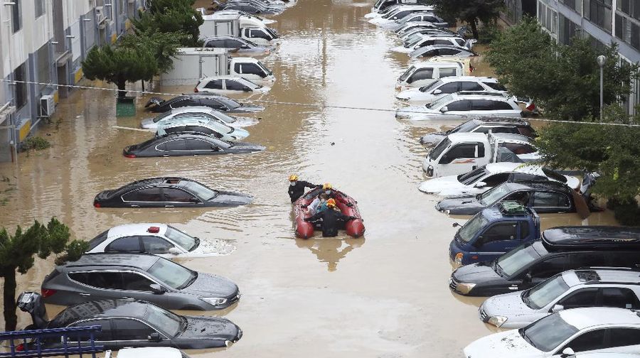 Rescue workers evacuate residents on a rubber boat to a safer place in Cheonan, South Korea, Monday, Aug. 3, 2020. Korean Meteorological Administration issued a warning of heavy rain for Seoul and central area. (Kim Jun-beom/Yonhap via AP)