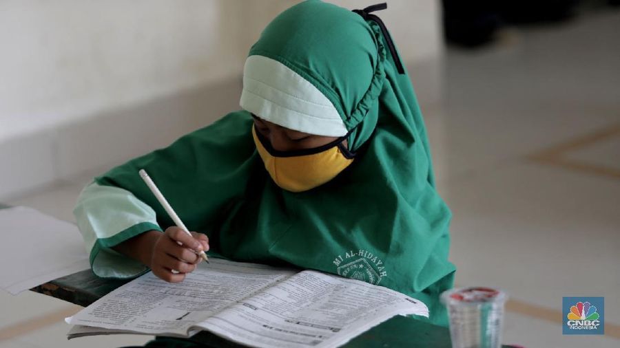 Belasan siswa melakukan kegiatan belajar mengajar sistem online di ruang aula kelurahan Jatirahayu, Bekasi, Jawa Barat. (CNBC Indonesia/Muhammad Sabki)