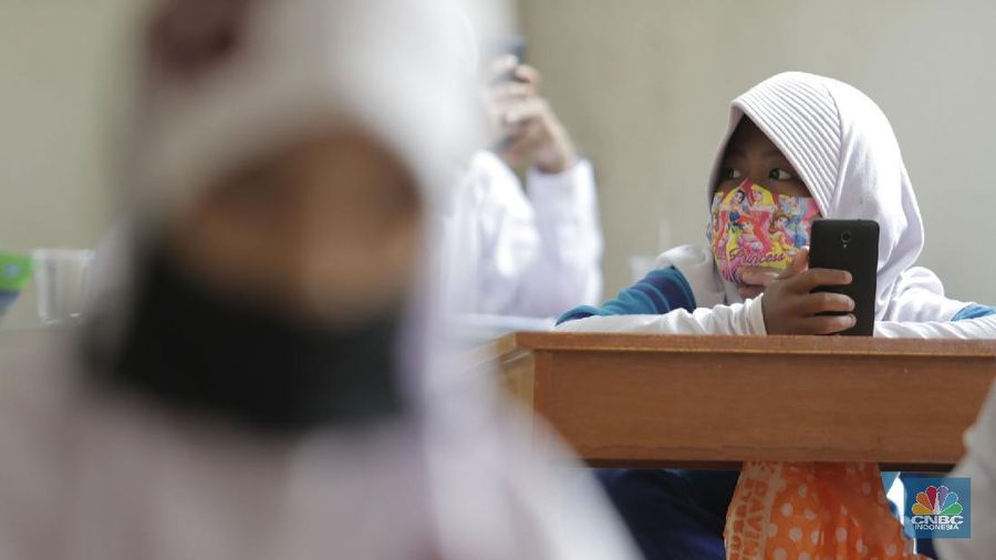 Belasan siswa melakukan kegiatan belajar mengajar sistem online di ruang aula kelurahan Jatirahayu, Bekasi, Jawa Barat. (CNBC Indonesia/Muhammad Sabki)