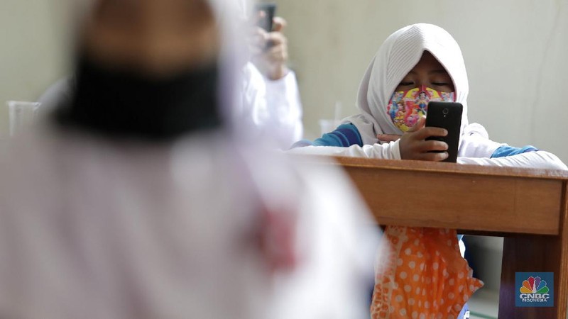 Belasan siswa melakukan kegiatan belajar mengajar sistem online di ruang aula kelurahan Jatirahayu, Bekasi, Jawa Barat. (CNBC Indonesia/Muhammad Sabki)