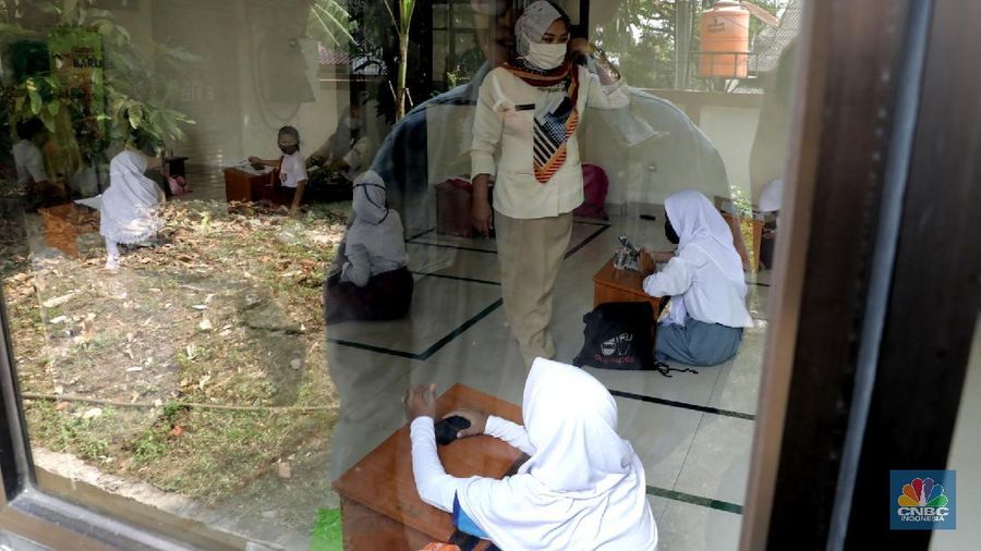 Belasan siswa melakukan kegiatan belajar mengajar sistem online di ruang aula kelurahan Jatirahayu, Bekasi, Jawa Barat. (CNBC Indonesia/Muhammad Sabki)