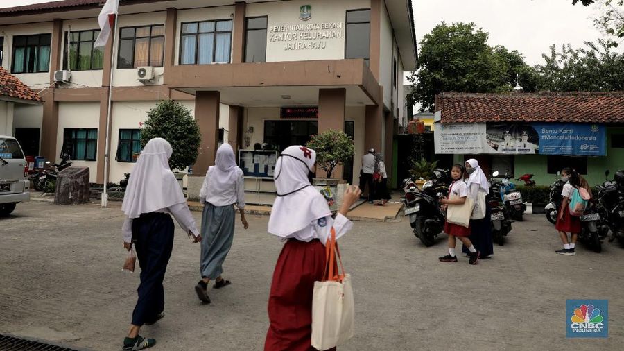 Belasan siswa melakukan kegiatan belajar mengajar sistem online di ruang aula kelurahan Jatirahayu, Bekasi, Jawa Barat. (CNBC Indonesia/Muhammad Sabki)