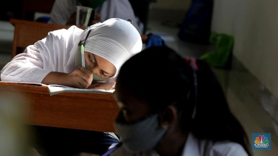 Belasan siswa melakukan kegiatan belajar mengajar sistem online di ruang aula kelurahan Jatirahayu, Bekasi, Jawa Barat. (CNBC Indonesia/Muhammad Sabki)