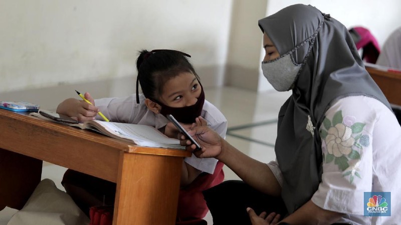 Belasan siswa melakukan kegiatan belajar mengajar sistem online di ruang aula kelurahan Jatirahayu, Bekasi, Jawa Barat. (CNBC Indonesia/Muhammad Sabki)