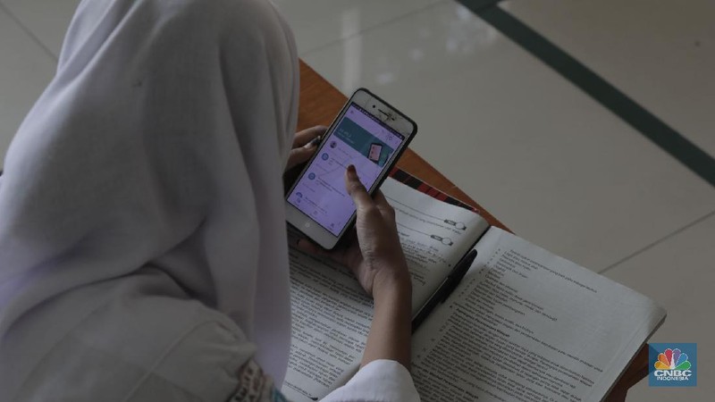 Belasan siswa melakukan kegiatan belajar mengajar sistem online di ruang aula kelurahan Jatirahayu, Bekasi, Jawa Barat. (CNBC Indonesia/Muhammad Sabki)