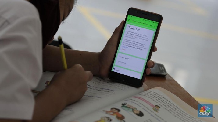Belasan siswa melakukan kegiatan belajar mengajar sistem online di ruang aula kelurahan Jatirahayu, Bekasi, Jawa Barat. (CNBC Indonesia/Muhammad Sabki)