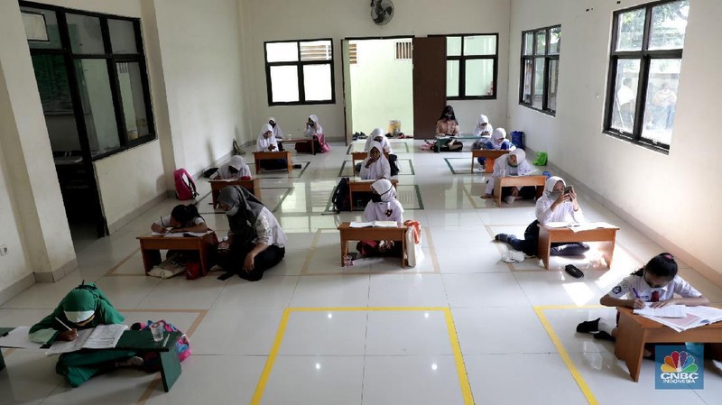 Belasan siswa melakukan kegiatan belajar mengajar sistem online di ruang aula kelurahan Jatirahayu, Bekasi, Jawa Barat. (CNBC Indonesia/Muhammad Sabki)