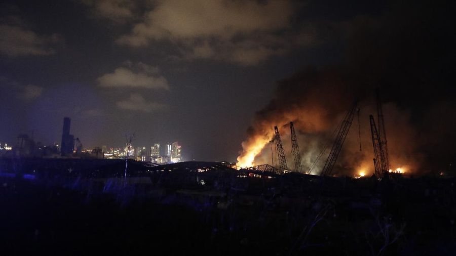 Fire burns after a massive explosion in Beirut, Lebanon, Tuesday, Aug. 4, 2020. Massive explosions rocked downtown Beirut on Tuesday, flattening much of the port, damaging buildings and blowing out windows and doors as a giant mushroom cloud rose above the capital. Witnesses saw many people injured by flying glass and debris. (AP Photo/Hassan Ammar)