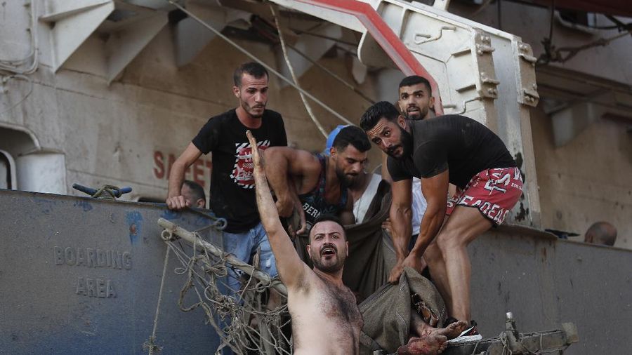 Fire burns after a massive explosion in Beirut, Lebanon, Tuesday, Aug. 4, 2020. Massive explosions rocked downtown Beirut on Tuesday, flattening much of the port, damaging buildings and blowing out windows and doors as a giant mushroom cloud rose above the capital. Witnesses saw many people injured by flying glass and debris. (AP Photo/Hassan Ammar)