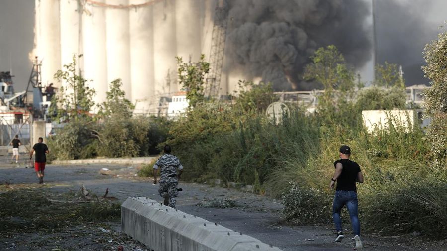 Lebanese security officers run to the explosion scene that hit the seaport, in Beirut Lebanon, Tuesday, Aug. 4, 2020. Massive explosions rocked downtown Beirut on Tuesday, flattening much of the port, damaging buildings and blowing out windows and doors as a giant mushroom cloud rose above the capital. Witnesses saw many people injured by flying glass and debris. (AP Photo/Hussein Malla)