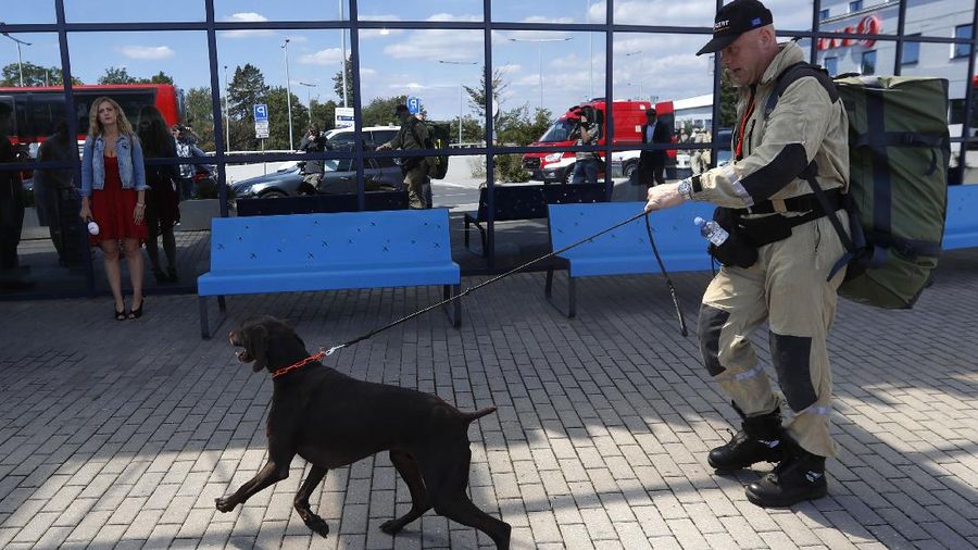 Anggota tim SAR Ceko beserta anjing pelacak berjalan menaiki pesawat di bandara Vaclav Havel di Praha, Rabu (5/8/2020). Republik Ceko mengirimkan sekitar 37 personel dan lima ekor anjing pelacak untuk membantu pencarian korban ledakan dahsyat di Beirut, Lebanon. (AP Photo/Petr David Josek)