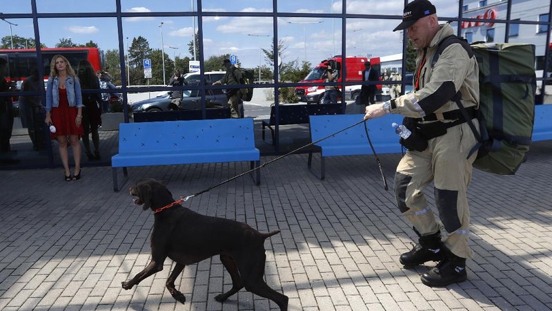 Anggota tim SAR Ceko beserta anjing pelacak berjalan menaiki pesawat di bandara Vaclav Havel di Praha, Rabu (5/8/2020). Republik Ceko mengirimkan sekitar 37 personel dan lima ekor anjing pelacak untuk membantu pencarian korban ledakan dahsyat di Beirut, Lebanon. (AP Photo/Petr David Josek)