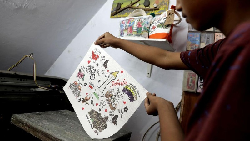Pengrajin saat menjahit tas kantongan berbahan kanvas organik/katun yang diproduksi menjadi sovenir khas Jakarta di Workshop AIU Craft, Jakarta Timur. (CNBC Indonesia/Muhammad Sabki)