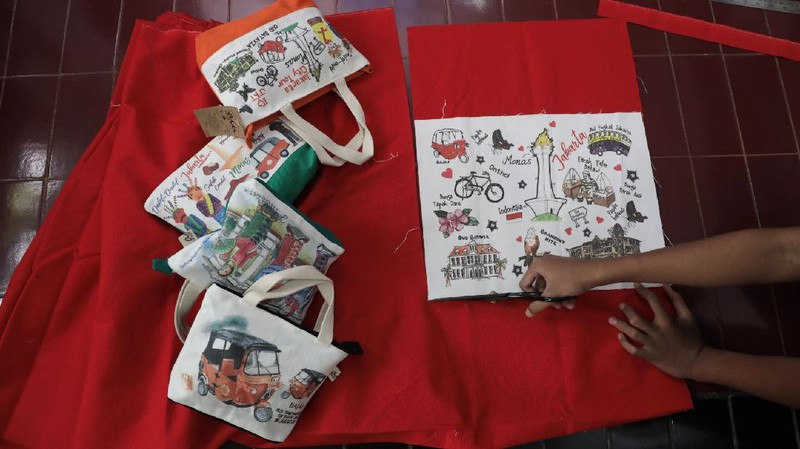 Pengrajin saat menjahit tas kantongan berbahan kanvas organik/katun yang diproduksi menjadi sovenir khas Jakarta di Workshop AIU Craft, Jakarta Timur. (CNBC Indonesia/Muhammad Sabki)